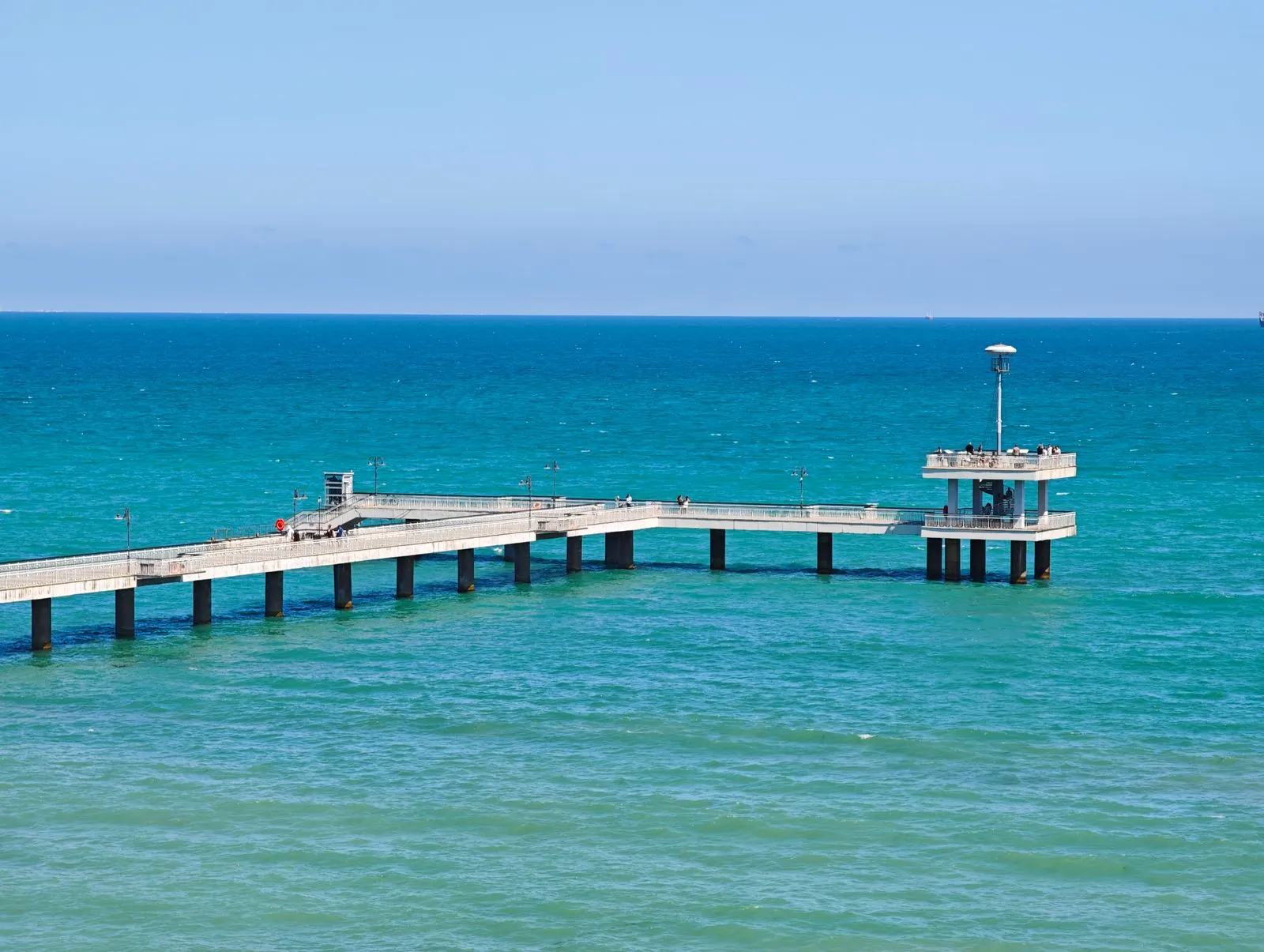 Pier in Varna stretching into turquoise Black Sea water. Photo by Ale.